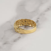 Rear interior view showing smooth band profile of a gold classic nugget ring on marble.