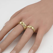 Two gold classic nugget band rings in different widths worn on a hand.