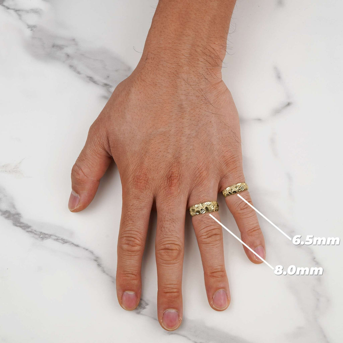 Hand model wearing 6.5mm and 8.0mm gold classic nugget band rings with width labels.