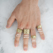 A complete hand layout displaying the width and fit of four textured gold nugget rings.
