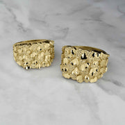 Two yellow gold classic nugget square rings side-by-side on a white marble background.