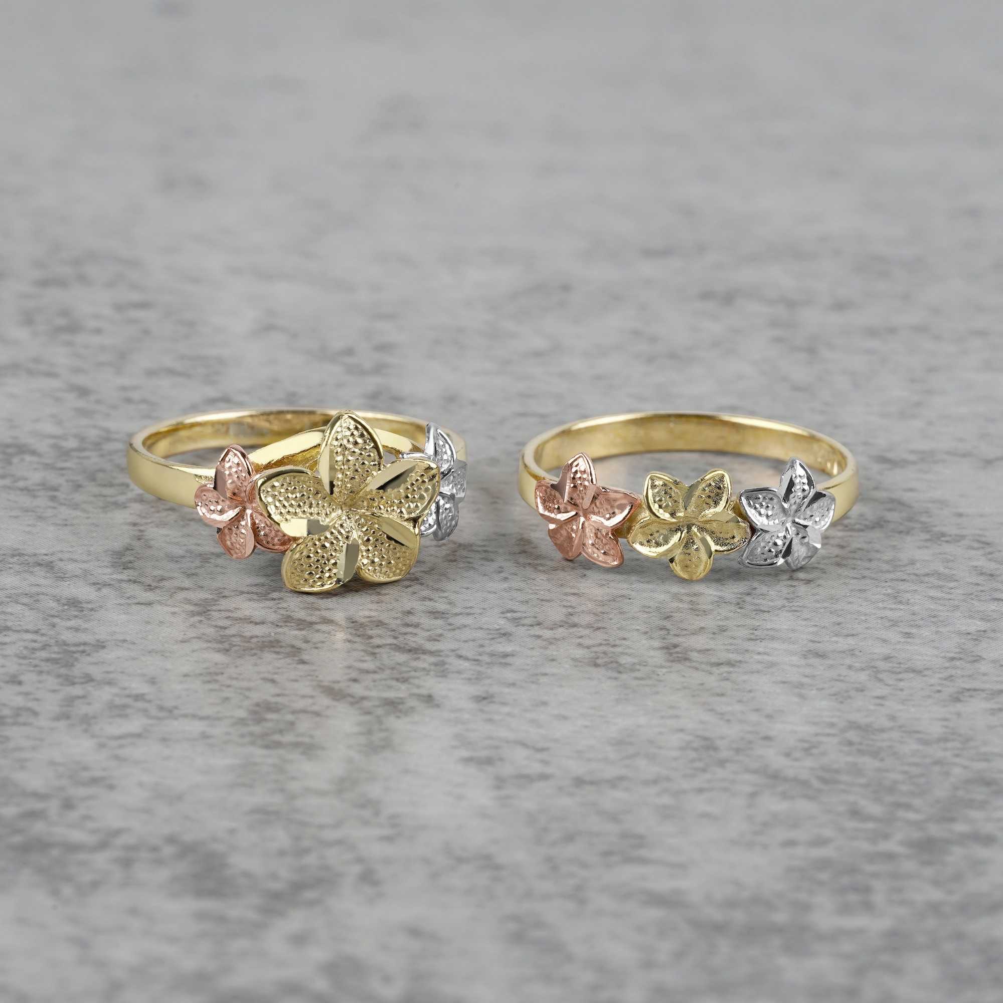 Two 10k- 14k floral patterned gold with white gold and rose gold on a gray surface.