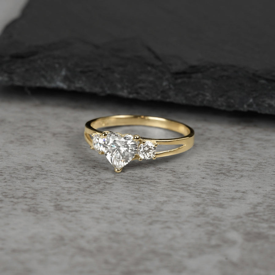 Front view of a gold three-stone ring with heart-shaped white stones on stone.