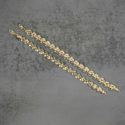 Two gold concave nugget heart link bracelets placed diagonally on a gray surface.