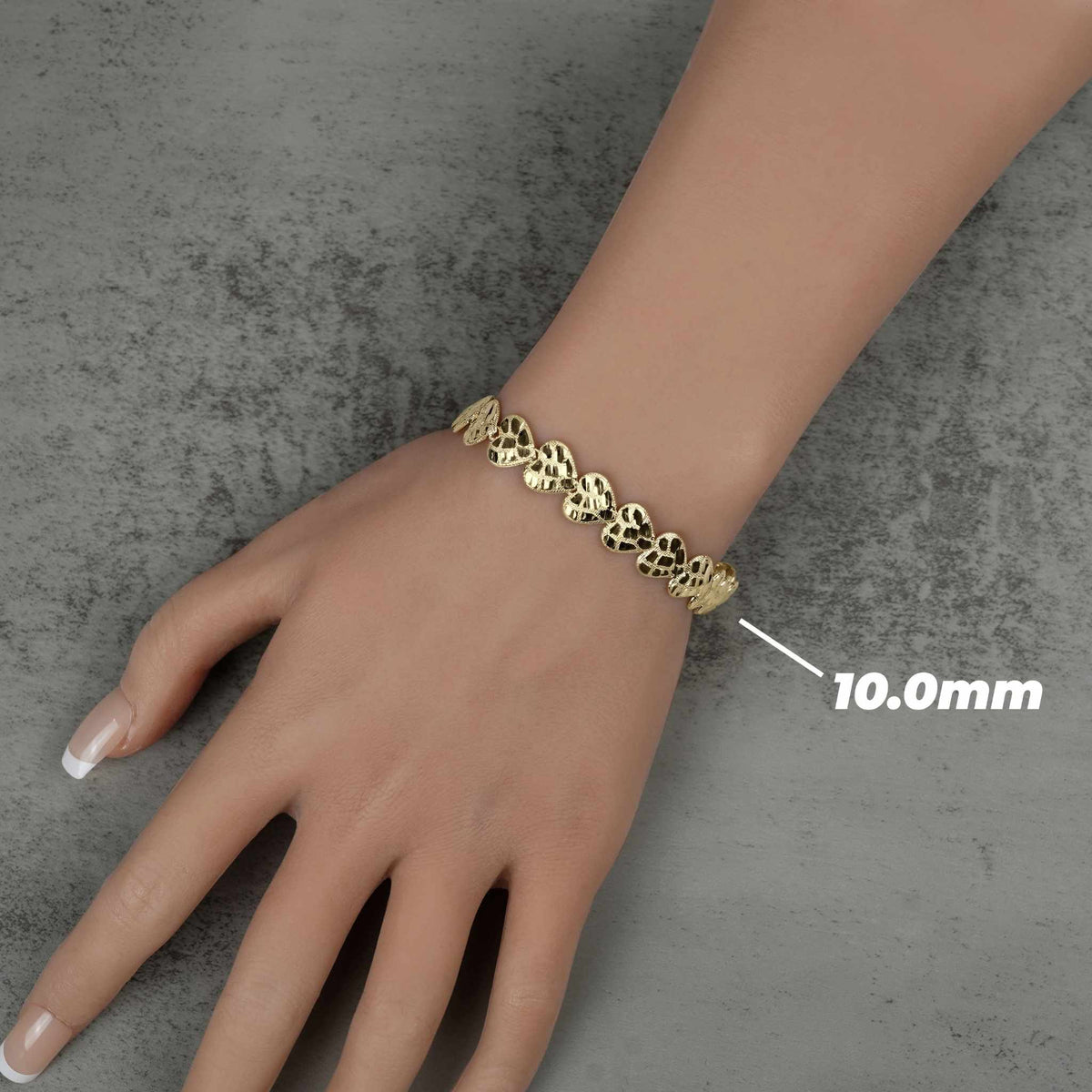 Top-down view of a 10.0mm gold nugget heart link bracelet on a hand.