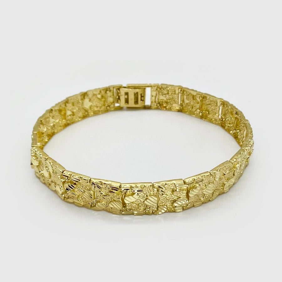 Yellow gold diamond-cut nugget vintage link bracelet displayed on a light background.