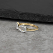 10k or 14k gold Elio infinity CZ ring displayed on a dark slate background.