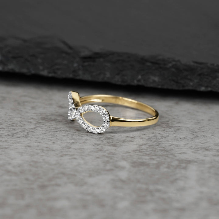 10k or 14k gold Elio infinity CZ ring displayed on a dark slate background.