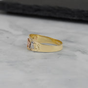 Side view of the tricolor gold ring resting on a white marble surface.
