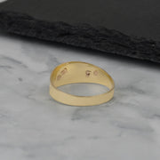 Interior view of the gold ring showcasing hallmark stamps against a dark background.