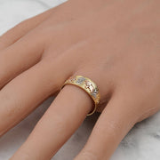 10k and 14k tricolor gold band displayed on a hand against a marble background.
