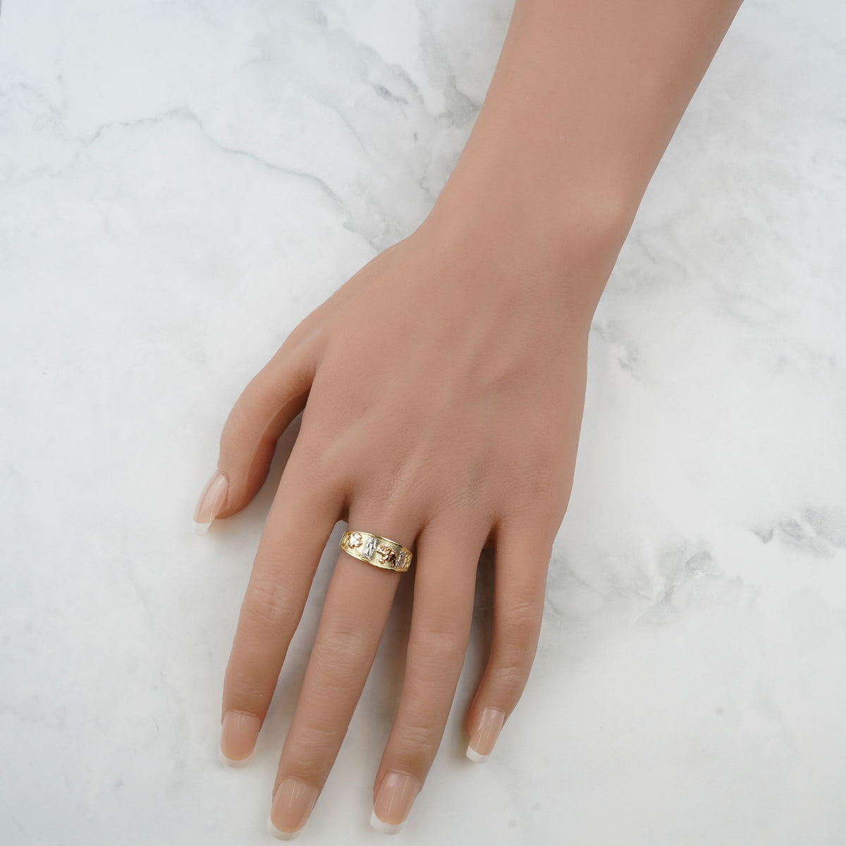 10k and 14k gold Evora ring showcased on a hand over marble.