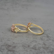 Two 10k - 14k gold rings with floral designs side view on a gray surface