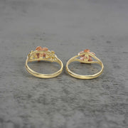 Two 10k - 14k gold rings with floral design back view on a gray surface