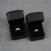 Two black jewelry boxes with two 10k - 14k gold rings with floral design