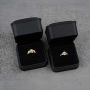 Two black jewelry boxes with two 10k - 14k gold rings with floral design 