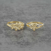 Two 10k - 14k gold rings with floral designs on a gray surface