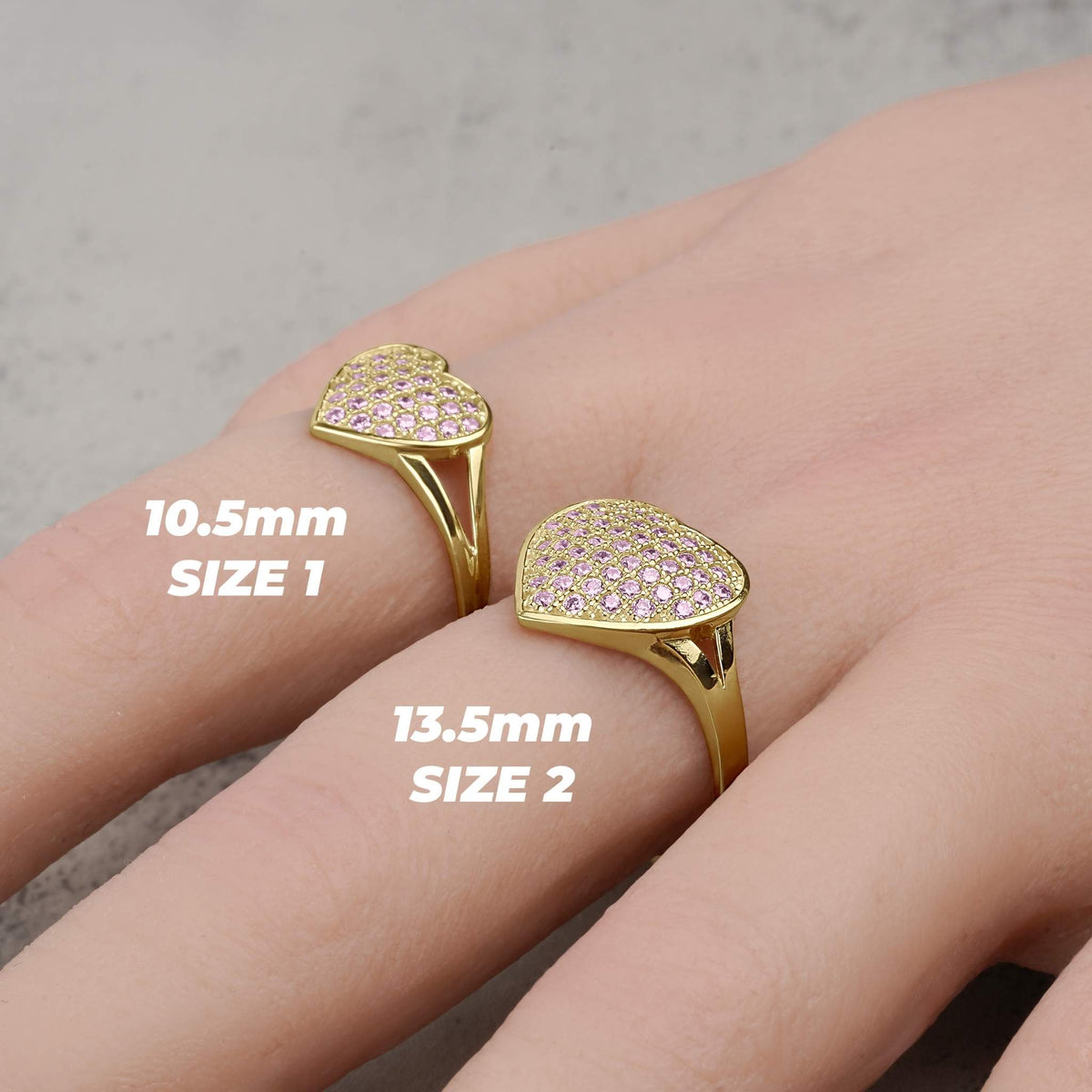 Gold convex heart rings in Size 1 and Size 2 displayed on a hand.