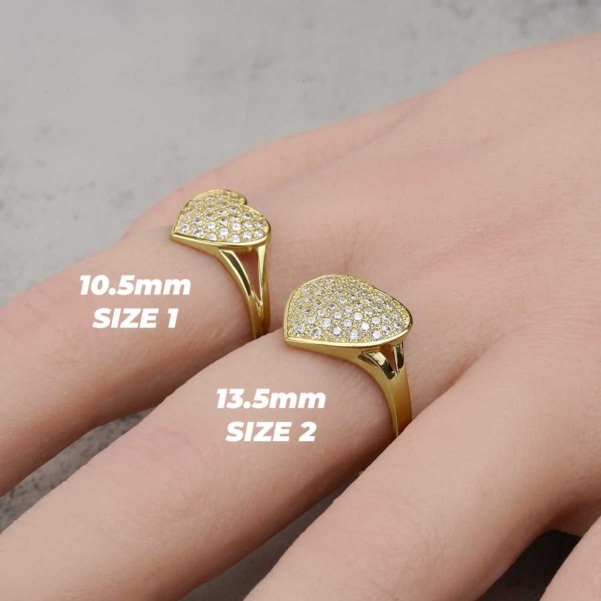 Gold convex heart rings in Size 1 and Size 2 displayed on a hand.