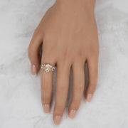 Close-up view of a model's hand showcasing the two-tone gold Virgin Mary ring.