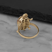 Underside view of a gold turtle locket ring showing its intricate ribbed pattern.