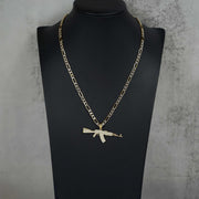 Product display of the gold AK-47 gun pendant necklace on a black bust.