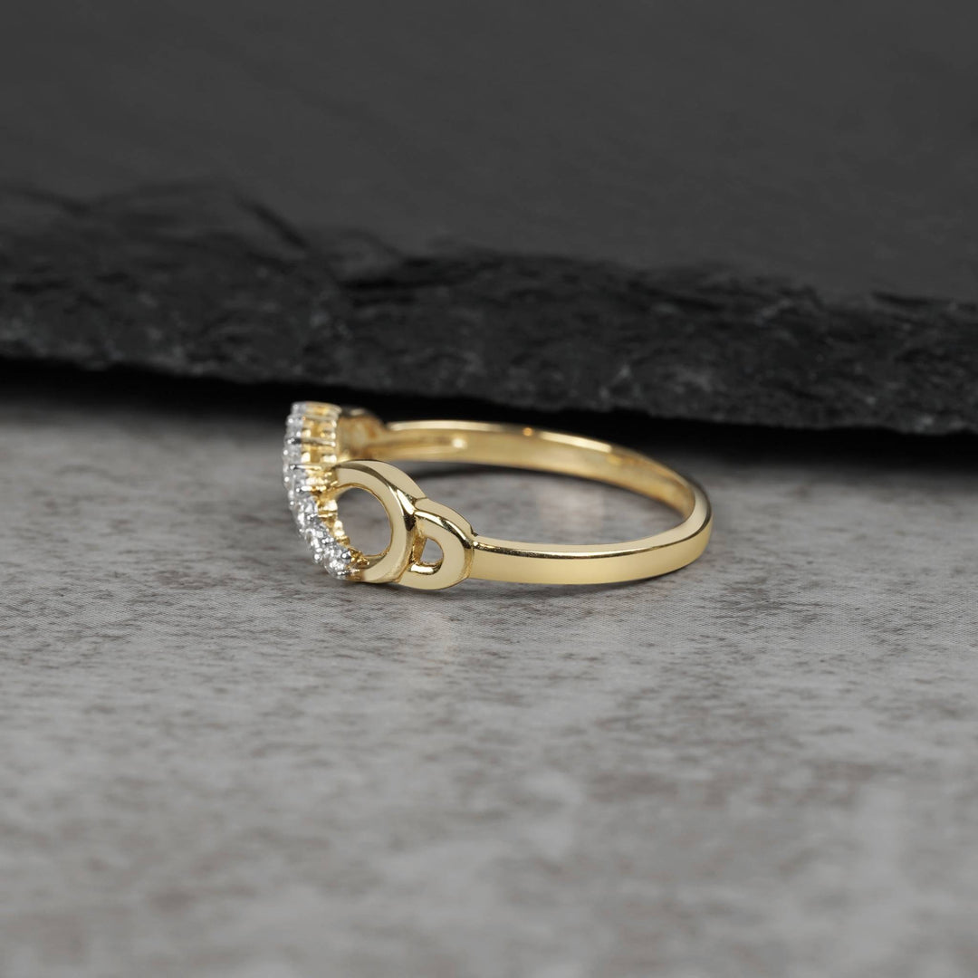 Side view of a gold infinity ring showcasing curved cubic zirconia stone settings