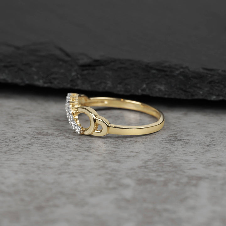 Side view of a gold infinity ring showcasing curved cubic zirconia stone settings
