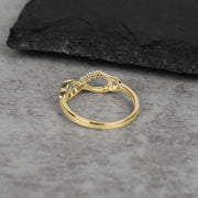 Inner band view of a gold infinity ring showcasing the cubic zirconia stone settings.