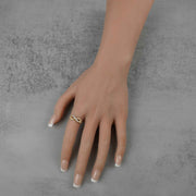 A woman’s hand wearing a gold infinity ring with clear cubic zirconia stones