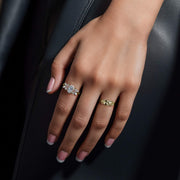 Model wearing a gold Lina slim nugget band ring on a dark background.