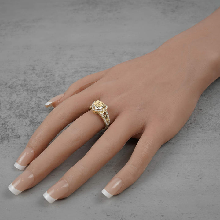 10k - 14k Hand wearing a gold ring with intricate design on a gray background