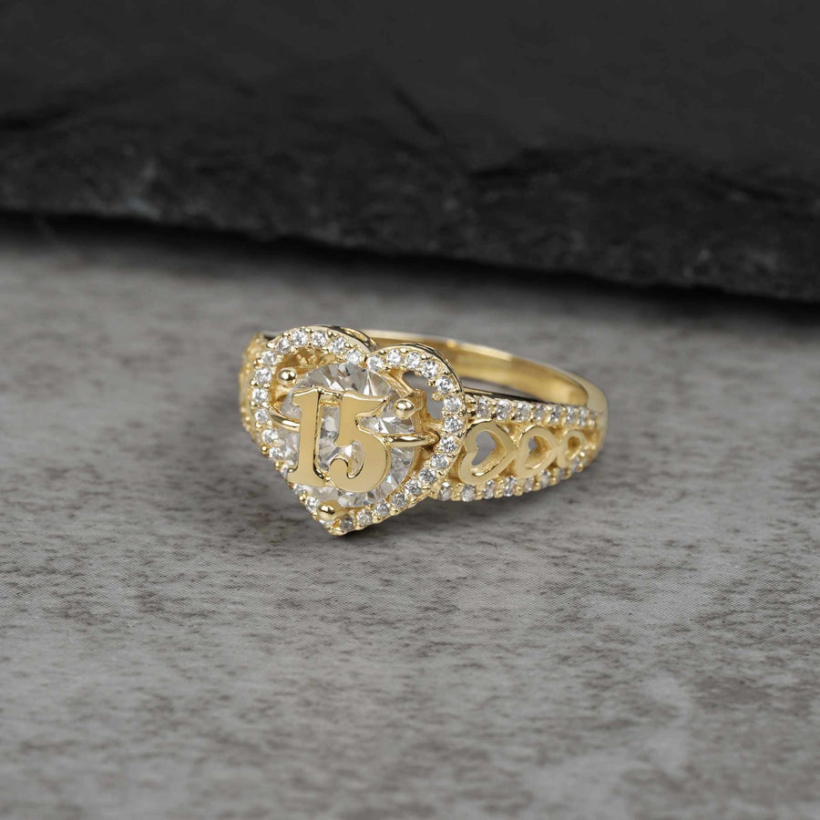 10k - 14k Gold ring with 15 and heart design on a gray surface