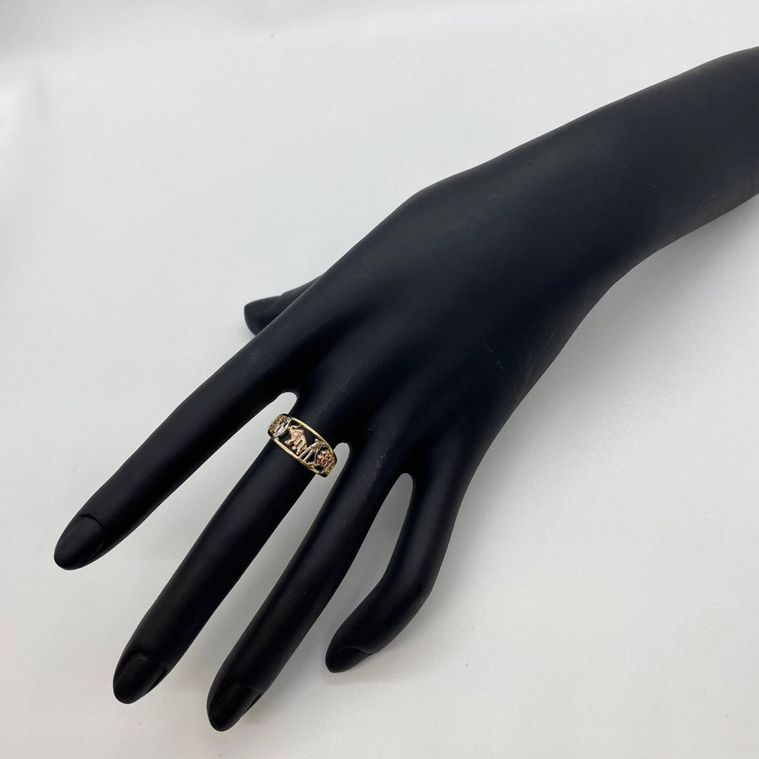 Black mannequin hand wearing a 10k - 14k gold ring with elephant design on a white background