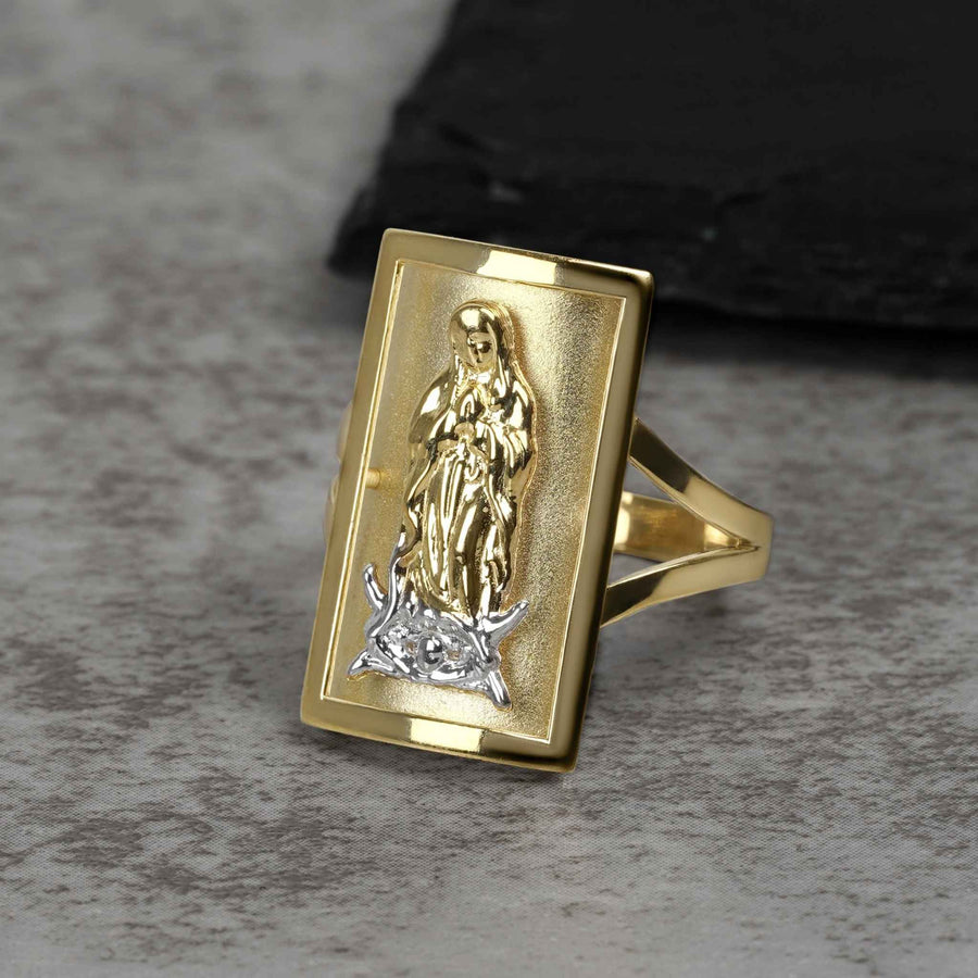 Rectangular two-tone gold ring featuring a detailed Virgin Mary engraving on a gray surface