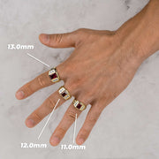 Model displaying three yellow gold rectangle signet rings with red gemstones on fingers.