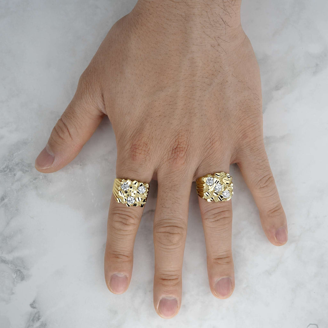 Two bold, textured yellow gold nugget rings with glittering gemstone accents displayed on a hand.