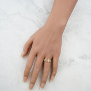 Close-up of a hand wearing the yellow gold Orin ring on marble.