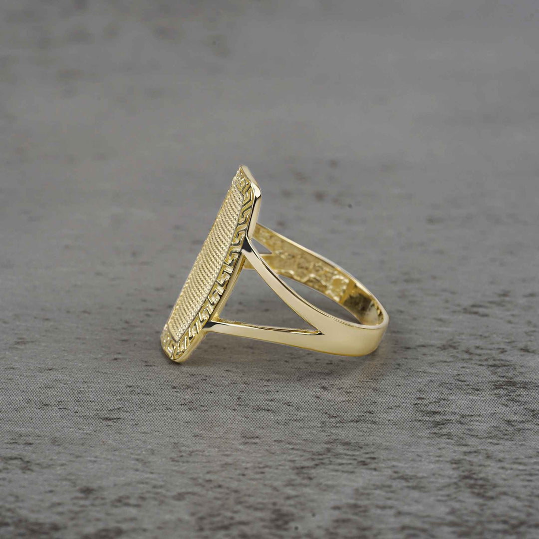 10k - 14k gold oval ring with textured design side view on a gray surface