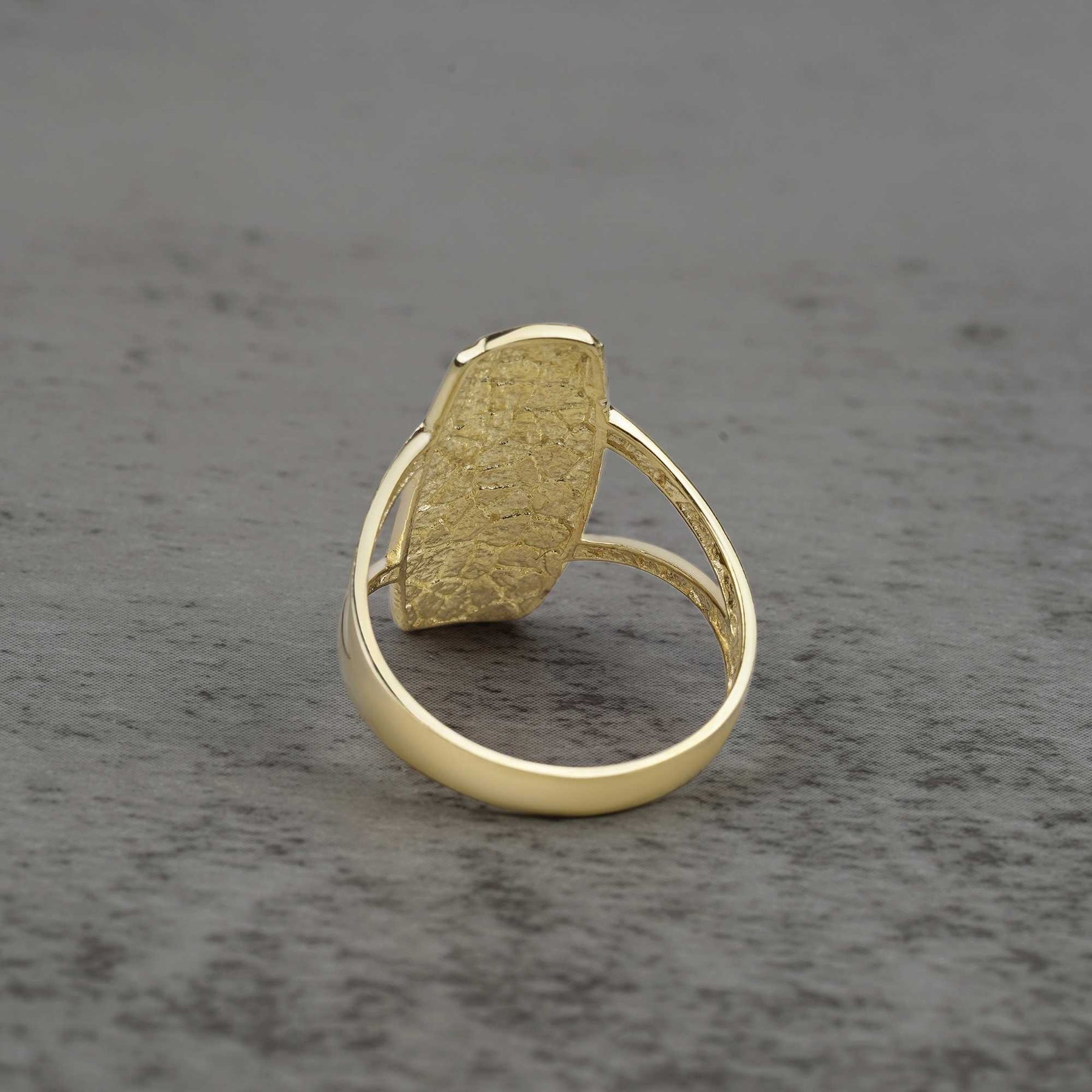 10k - 14k Gold ring with a textured oval shaped design back view on a gray background