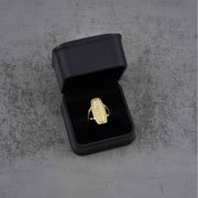 10k - 14k Gold oval ring in a black jewelry box on a gray surface