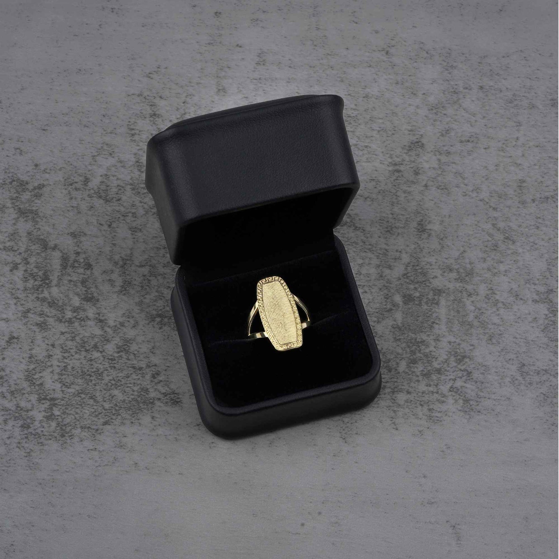 10k - 14k Gold oval ring in a black jewelry box on a gray surface
