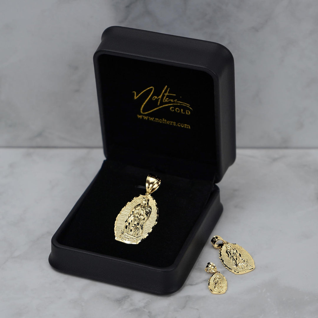 Gold religious pendant and matching earrings presented in an open black 'Nolters' jewelry box.