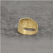 Inside view of a gold ring showing a detailed, recessed engraving of religious figures.