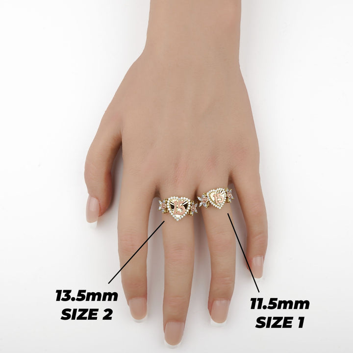 Hand wearing two gold heart Quinceañera rings showing Size 1 and Size 2 comparison.