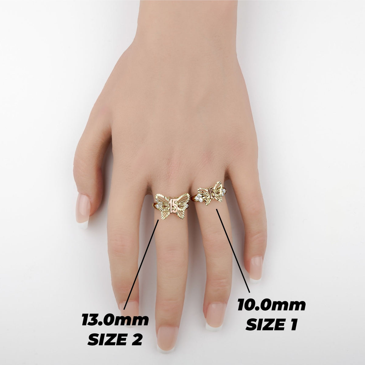 Hand wearing two gold butterfly Quinceañera rings showing Size 1 and Size 2 comparison.