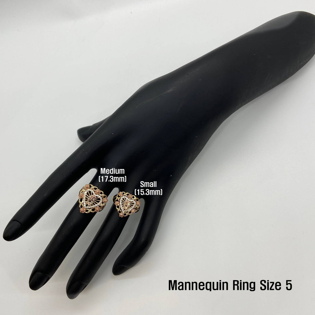 Two 10k- 14k gold Bloom Rose heart-shaped rings on a black mannequin hand with size labels.