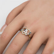 Model wearing a yellow gold ring with a tri-color number 15 heart design