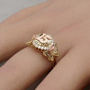 A gold two-tone Quinceañera 15 ring with rose details being worn on a finger.