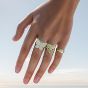 Model wearing a gold Rav butterfly CZ ring alongside other gold statement rings.